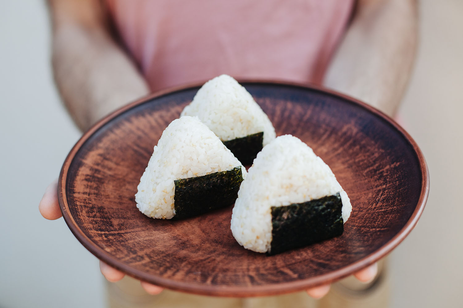 Onigiri: bolinho de arroz japonês em formato triangular com pedaço de alga nori.